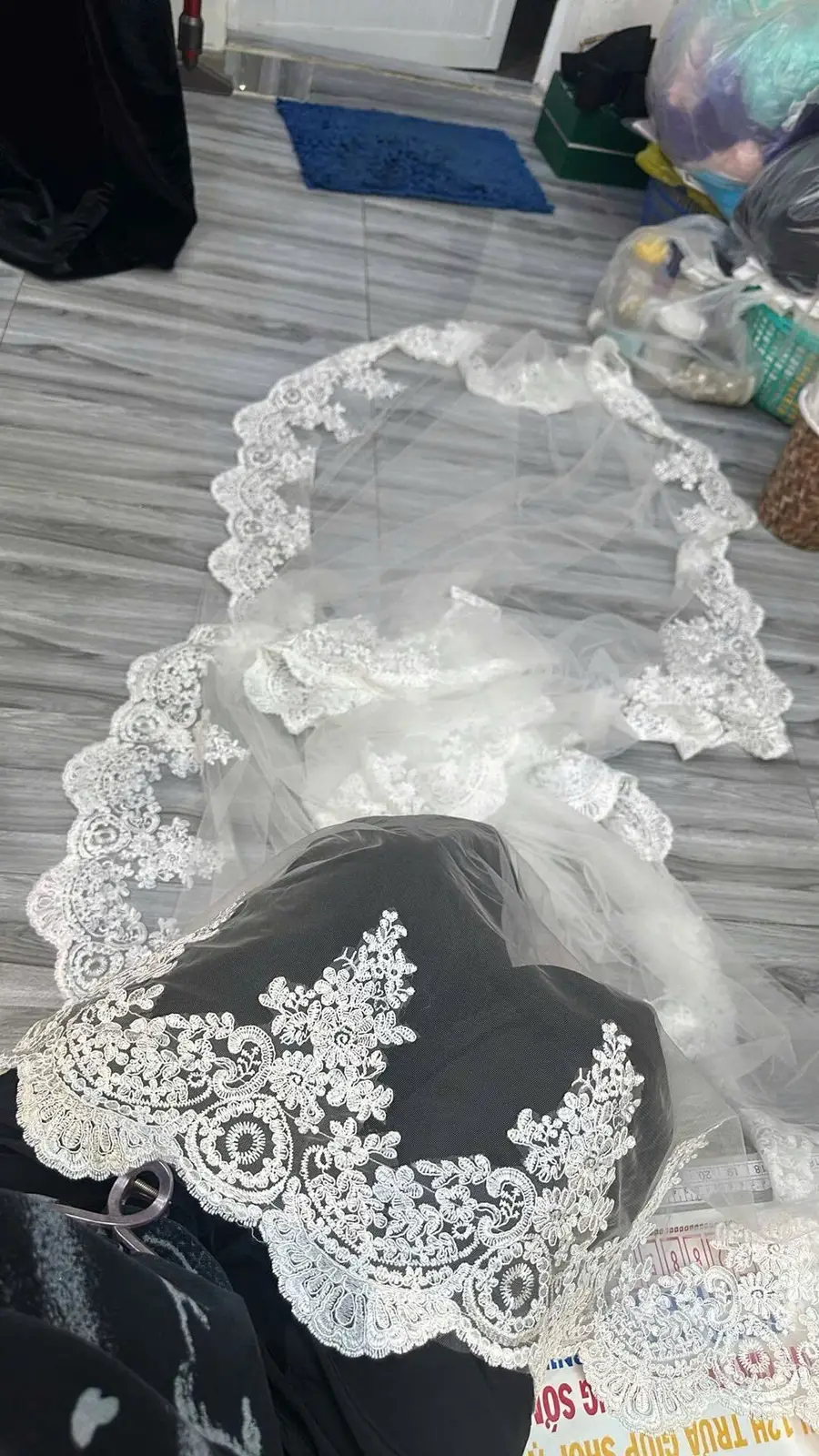 White lace veil in progress with lace placement reviewed inside the VI Dressmakers atelier
