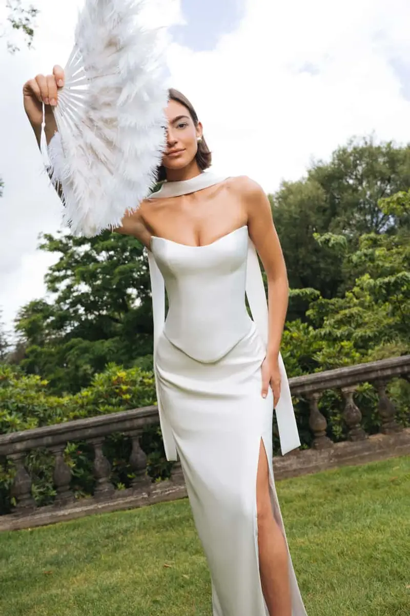 Reference look Mei Lin sent — strapless corset split Aline with neck scarf, thigh slit, and feather fan, sculptural evening silhouette