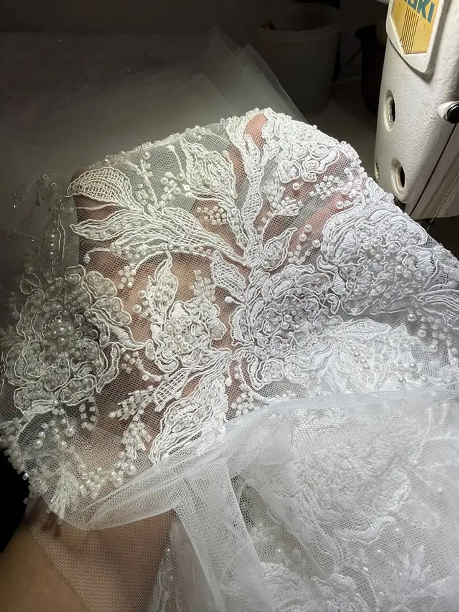 Close-up of bridal lace and pearl embroidery used to review lace surface and lining direction