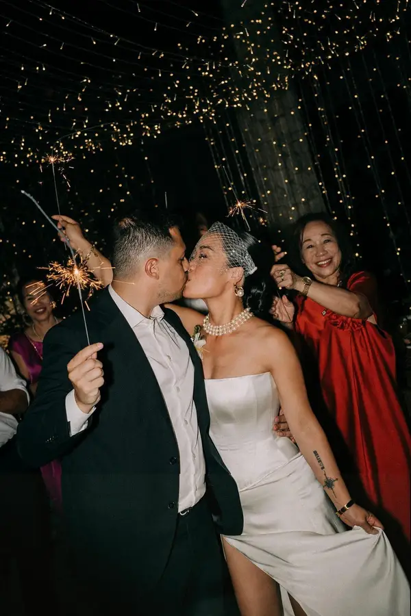 Ivory satin corset wedding dress during sparkler celebration, custom-made by VI Dressmakers Vietnam for Singapore