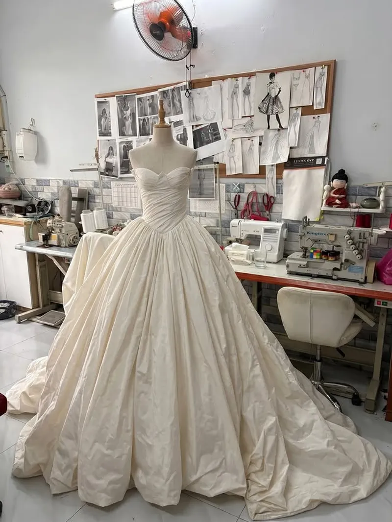 Stock photo: bride in a sculpted white gown with a long train — liquid silk-satin drape and highlight on the body