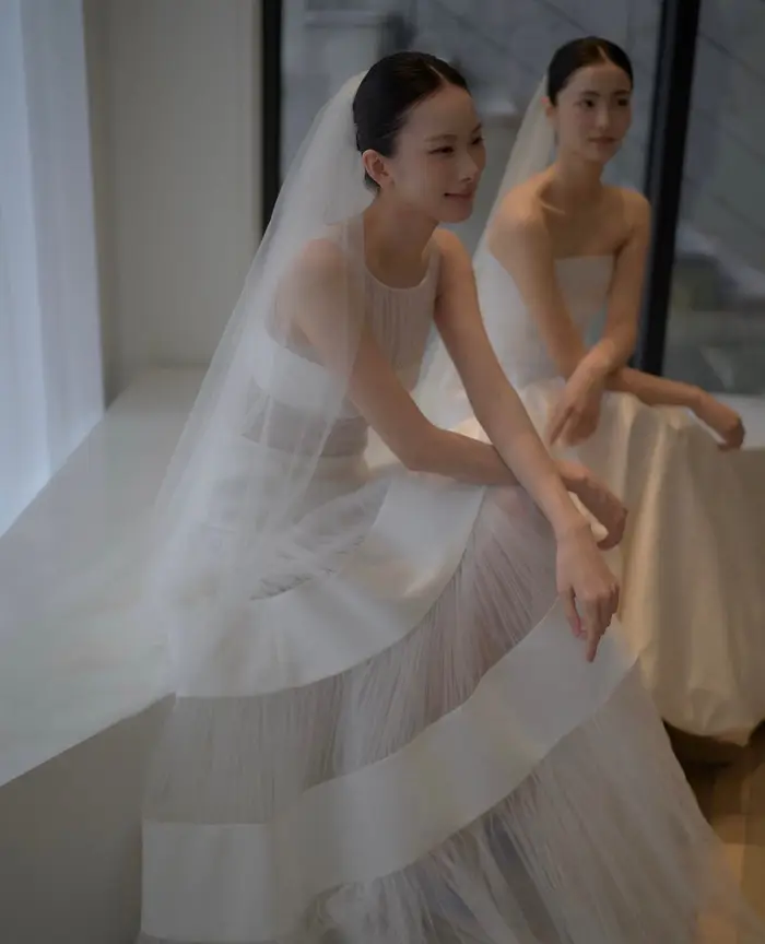 Client inspiration — seated editorial look with sheer neckline, Mikado bands, and veil